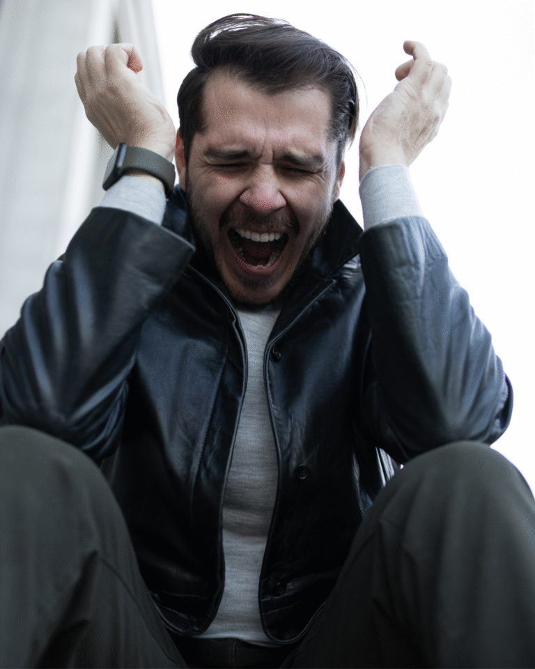 Hombre gritando con las manos en la cabeza