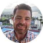 Professional headshot of John Capps, PhD, smiling outdoors in San Diego at the Clinical TMS Conference in 2025, representing NeuroSpa Clinic’s TMS, neurotherapy, and brain health services in Ciudad Juárez and El Paso.