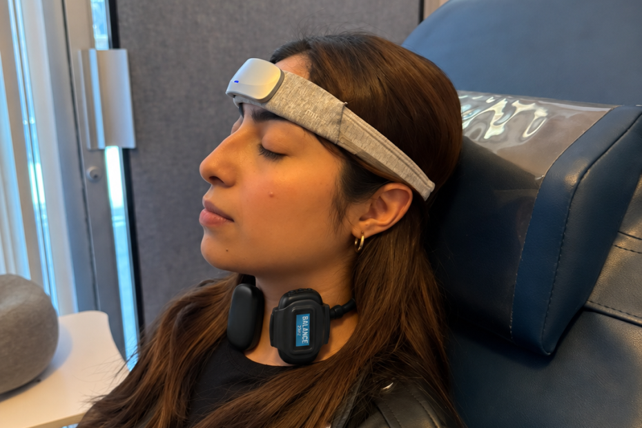 Persona recostada en silla azul de NeuroSpa con dispositivo externo de estimulación eléctrica colocado en el cuello y banda de neuroterapia en la frente.